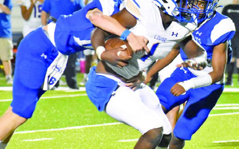 SILAS HETLAND AND Mark Moore make a tackle last Friday against Louise. Snook lost 35-22. -- Tribune photo by Roy Sanders