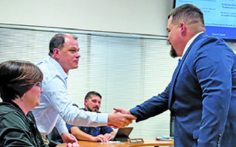 SNOOK SCHOOL BOARD member Adam Janac welcomes Matthew Kana to the Snook ISD family as its new athletic director and head football coach. Tribune photo by Denise Squier