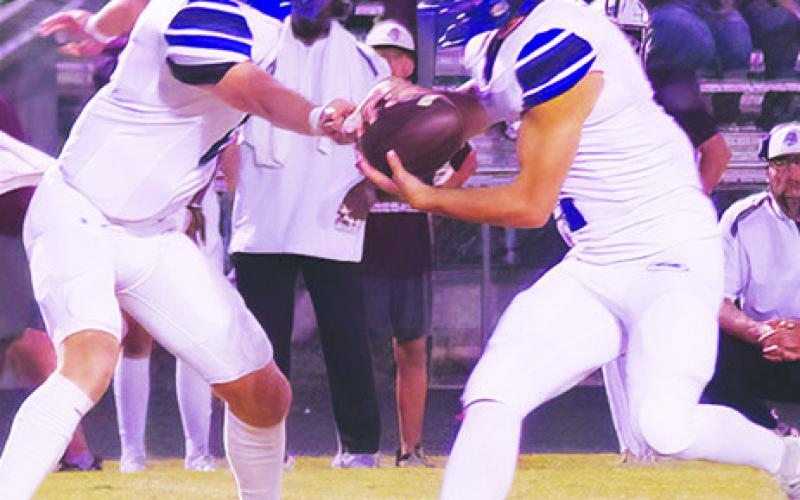SNOOK’S BRETT Withem hands off to Tristan Yen in the Iola game last Friday. Photo courtesy of Steve Ingram
