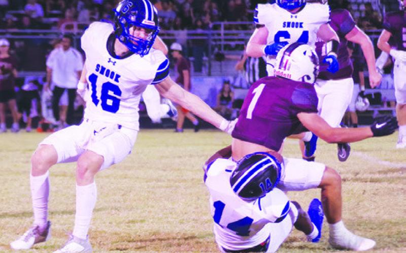 SNOOK’S BUD MORE makes a tackle against Iola last Friday in Iola. Also pictured is teammate Silas Hetland. Photo courtesy of Steve Ingram