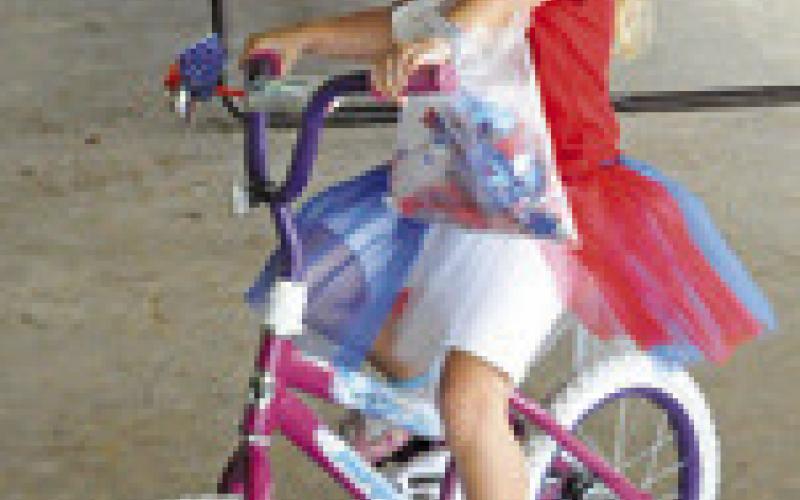 CHILDREN AND BIKES adorned in red, white and blue were featured during the July 4 Fun Walk/Run at the Snook City Park. Tribune photo by Denise Squier