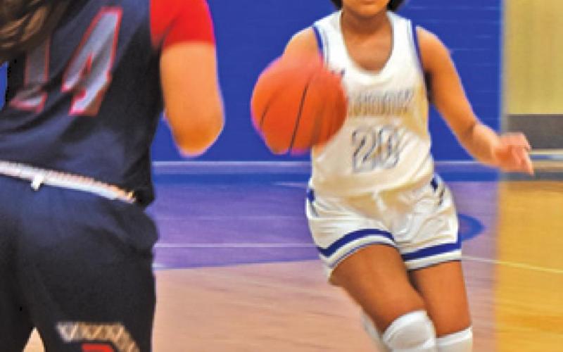 SNOOK’S ALANA STRINGFELLOW dribbles the ball down the court while Madisonville’s Makayla Ford waits on defense.