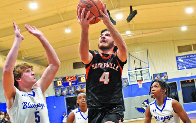 KASON ROHRBACH OF Somerville leaps for this shot as Brayden Macik of Snook defends. Somerville won 46-34. Tribune photo by Roy Sanders