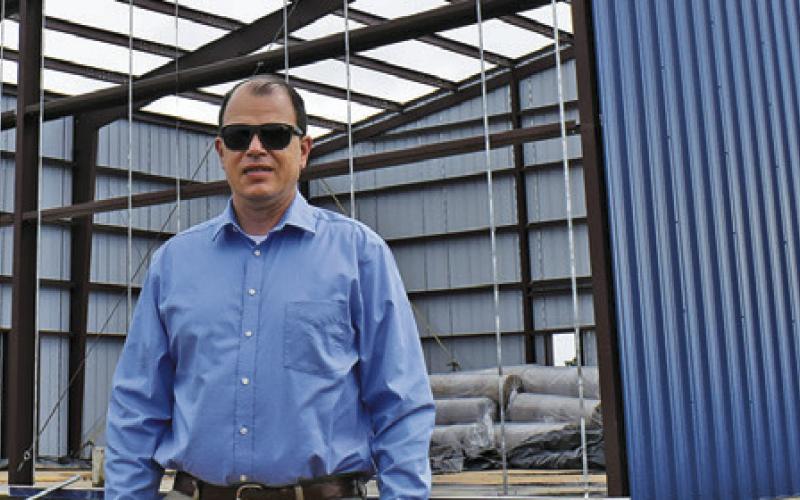 ADAM JANAC STANDS at the construction site for the C-LARS building in Snook. Tribune photo by Roy Sanders