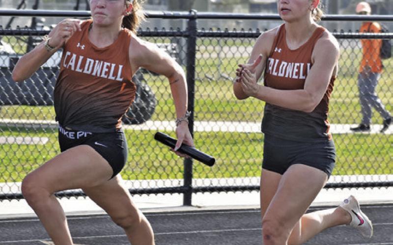 CALDWELL’S RAYLEIGH LAWHON receives the baton from teammate Natalie Eastepp during the Bluejay Relays last week. Tribune photo by Roy Sanders