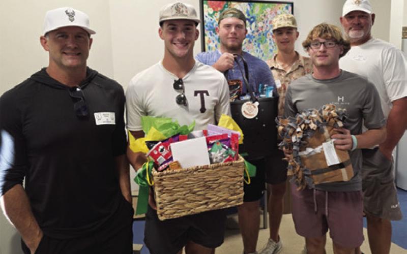 CALDWELL HIGH SCHOOL football players and Coach Witherwax visit Jurian Moore in the hospital in Austin.