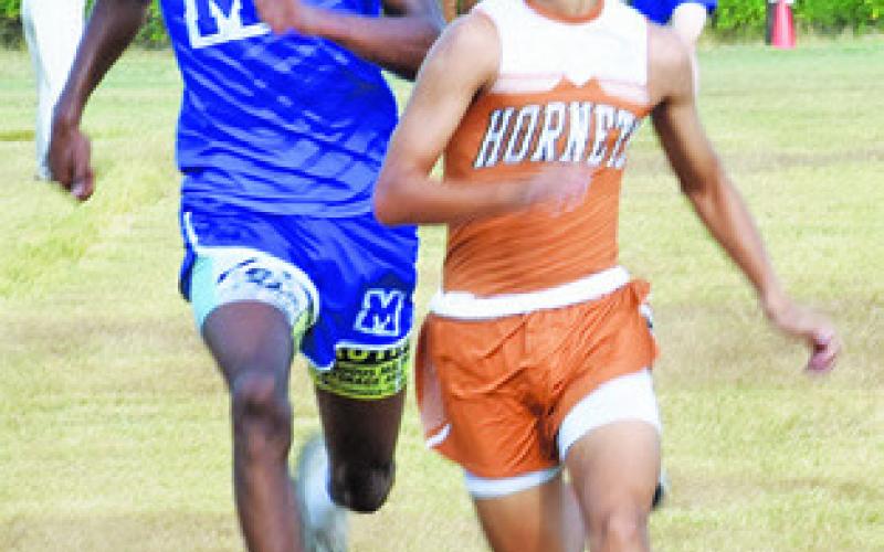 CALDWELL’S SPENCER ELLIS, right, and Mumford’s Braeden Mack fight for first place at the finish line of the high school boys race at Saturday’s Caldwell Cross Country Invitational. -- Tribune photo by Roy Sanders