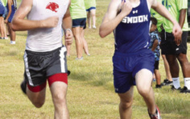 SNOOK’S ETHAN JANAC, RIGHT, edges out Burton’s Hunter Hancock for third place by one second in the high school boys race at Saturday’s Caldwell Cross Country Invitational.