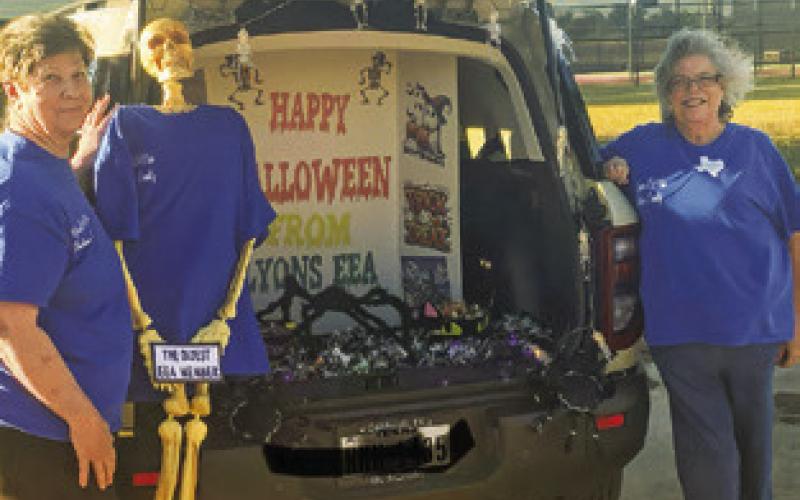 AT A LOCAL TRUNK-OR-TREAT, the Lyons EEA Club dug up their oldest member for the fun. Pictured, from left, are Brenda Kolojaco, the “oldest member” and Tammy Qualls-Tucker.