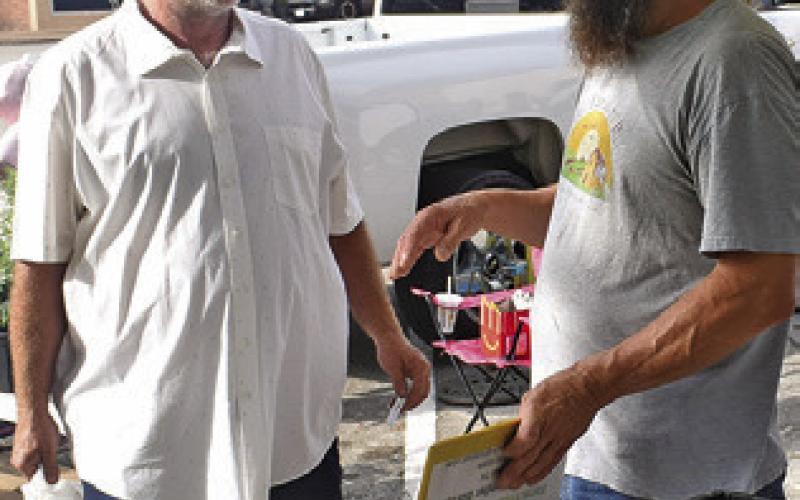 ERIC BONIOL, right, works on Saturday at the Farmers Market in downtown Caldwell.
