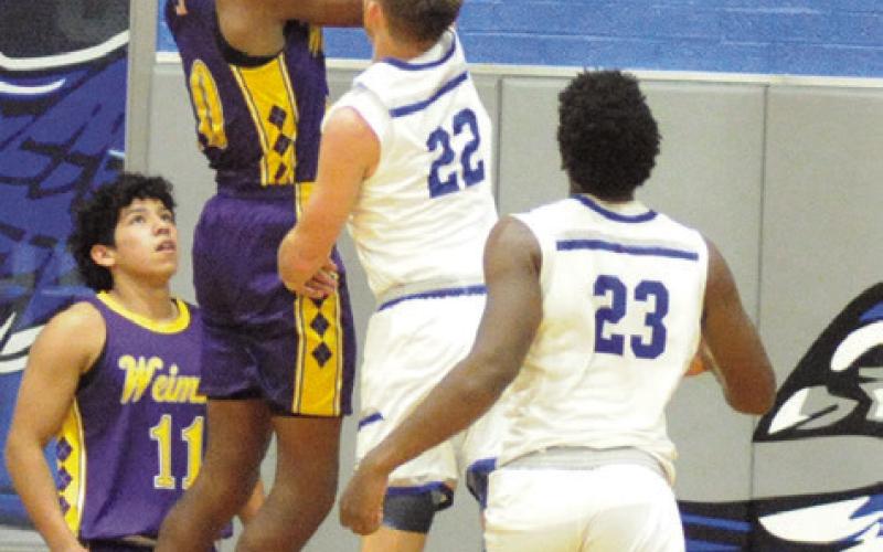 THE SNOOK DEFENSE tries to block this shot against Weimar. Snook won 52-35 to improve to 14-2 for the season. Tribune photo by Denise Squier