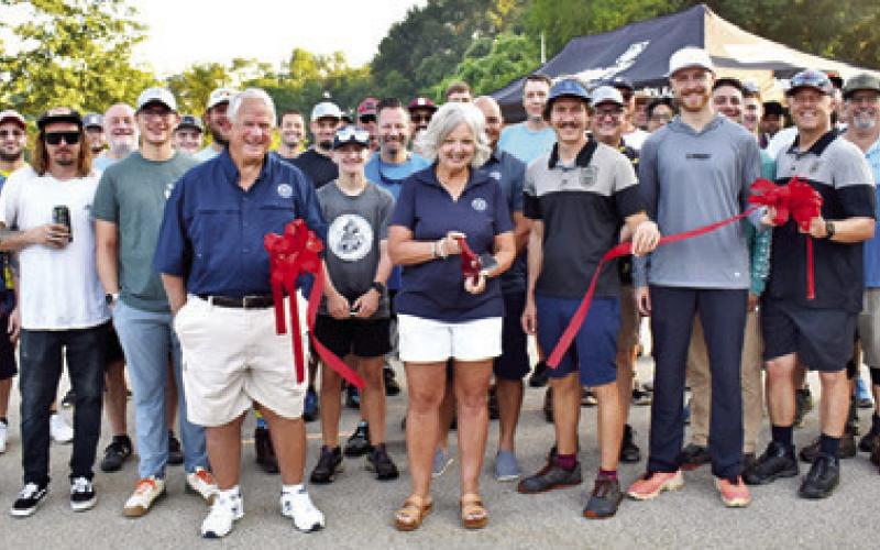 CALDWELL MAYOR JANICE Easter cuts the ribbon for the newly expanded disc golf course at a grand opening on Saturday morning, June 15, at John E. Hejl Park at Davidson Creek. Alderman Gary Easter and officials with Armory Disc Golf are pictured just prior to a tournament drawing numerous disc golfers from around the Brazos Valley.
