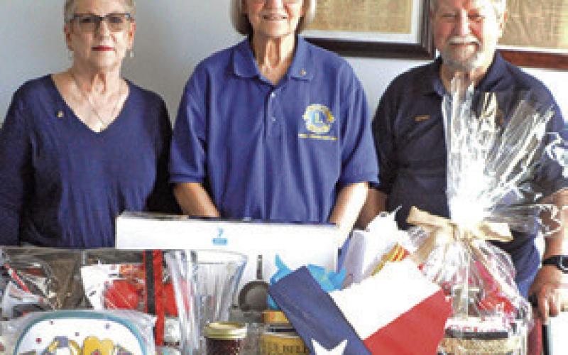 CALDWELL BURLESON County Lions Club members Kathy Cornett, Pat Drouilhet and Adrien Drouilhet III are pictured with some of the auction items for the Denim, Dinner and Dancing Gala. See story inside. Tribune photo by Denise Squier