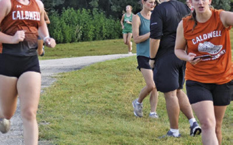 COACH KYNDALL TONN, RIGHT, encourages Caldwell runner Abby Lopez during Saturday’s Caldwell Cross Country Invitational Meet. Tribune photo by Roy Sanders