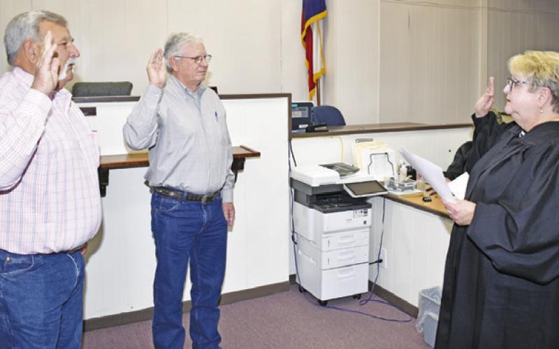 PRECINCT 4 COMMISSIONER ROBERT Urbanosky, left, and Precinct 2 Commissioner Vincent Svec are sworn in by Judge Towslee Corbett. -- Tribune photo by Roy Sanders