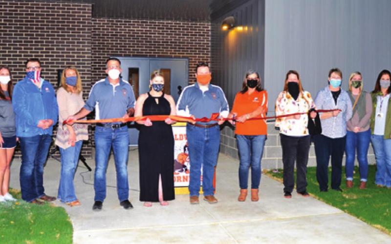 CALDWELL HIGH SCHOOL TEACHERS and Caldwell ISD School Board members prepare to cut this ribbon during the official ribbon cutting ceremony for the new CTE facility at the high school on Monday, Nov. 16. -- Tribune photo by Roy Sanders
