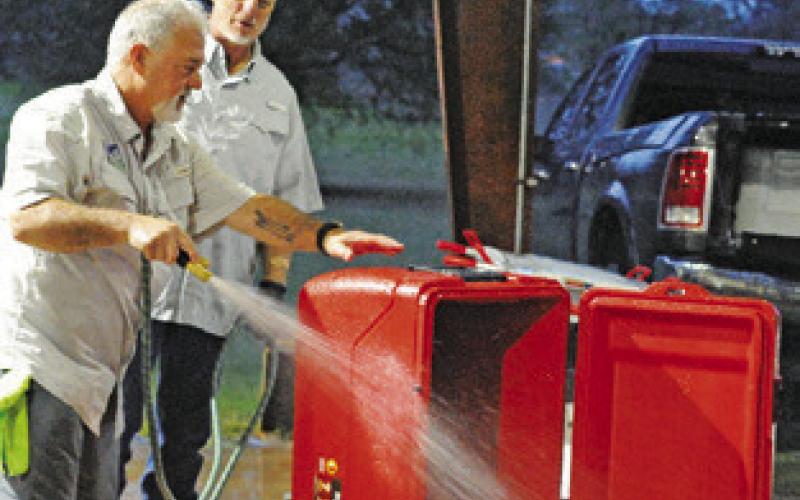 PETE GLIDEWELL CLEANS out this ice chest during Saturday’s shrimp and crawfish dinner fundraiser for Cops4Kids. Tribune photo by Denise Squier