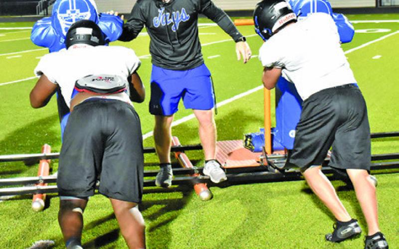 SNOOK HEAD COACH Nolan Lanham works with the line on this blocking sled drill. -- Tribune photo by Roy Sanders