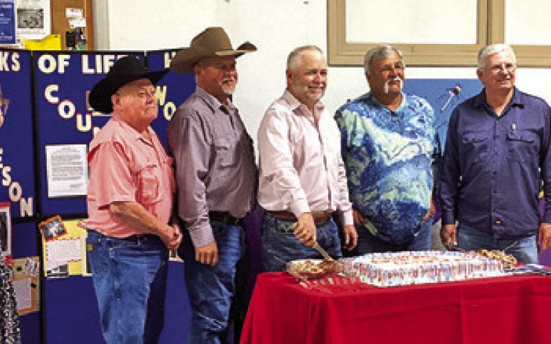 BURLESON COUNTY COMMISSIONERS gather around the cake for the county’s Heritage Week celebration. Pictured from left are Melynda Giesenschlag of the county’s historical commission and county commissioners David Hildebrand, Dwayne Faust, County Judge Keith Schroeder, and commissioners Bobby Urbanosky and Vincent Svec.