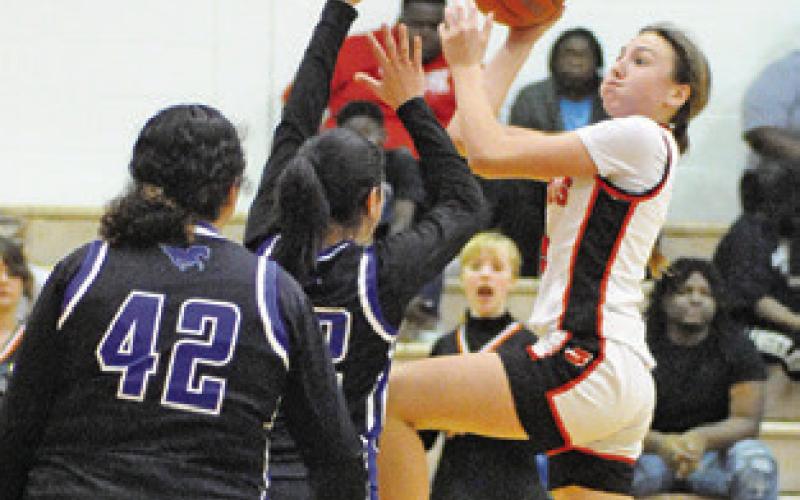 ABIGAIL RICHARDSON leaps above Mumford players to take a shot during the Somerville- Mumford game last Friday. Tribune photo by Denise Squier