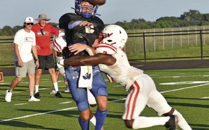 THE BALL COMES loose after this tackle in the Snook-Bremond scrimmage on Friday in Snook. -- Tribune photo by Roy Sanders