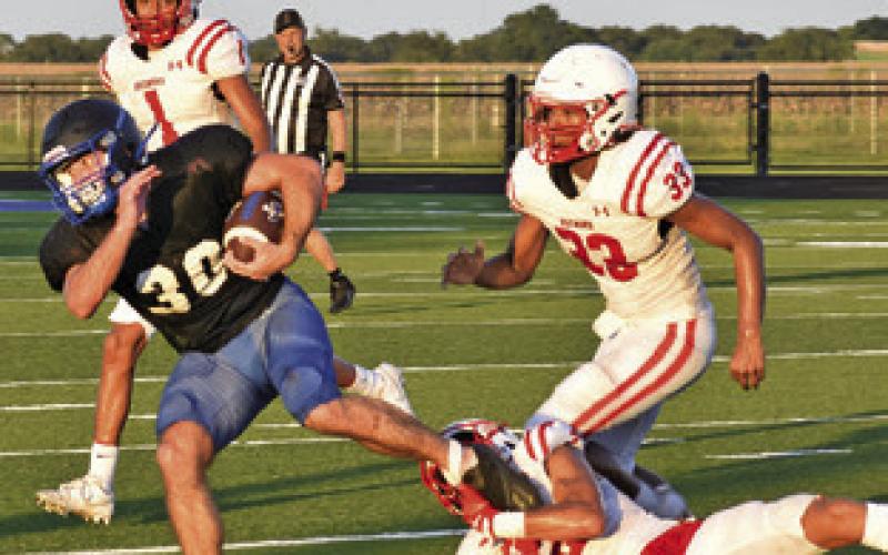 THE SNOOK OFFENSE moves the ball on Friday against Bremond as this Bremond defender tries to make the tackle.