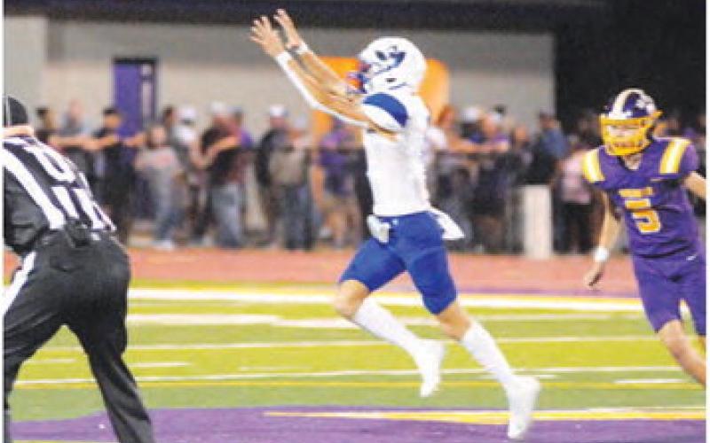 BRETT WITHEM OF SNOOK reaches high for this pass against Weimar last Friday.