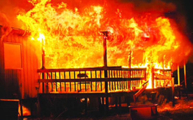 FLAMES ERUPT FROM the porch area of this house at Beaver Creek Subdivision. Photo courtesy of Snook Volunteer Fire Dept.