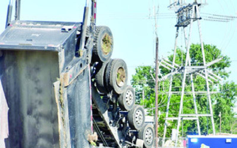 EMERGENCY RESPONDERS work the scene of this June 6 accident off State Highway 36. Tribune photo by Roy Sanders