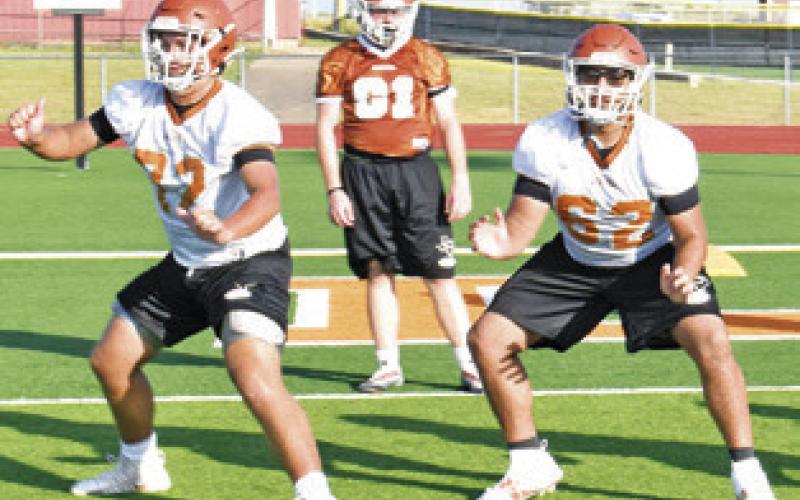 CALDWELL’S OFFENSIVE LINEMEN work on blocking techniques in the fall opening workout on Monday at Hornet Stadium.