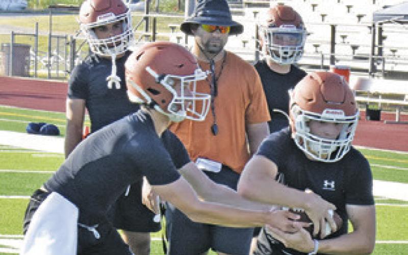 CALDWELL FOOTBALL players work on the handoff exchange on Monday on the first day of fall workouts at the high school.