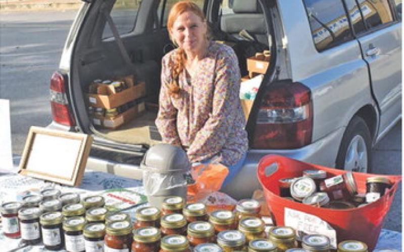 AUDREY GUTKE WORKS on Saturday at the booth for Hope Springs Farm at the weekly farmers market in downtown Caldwell.