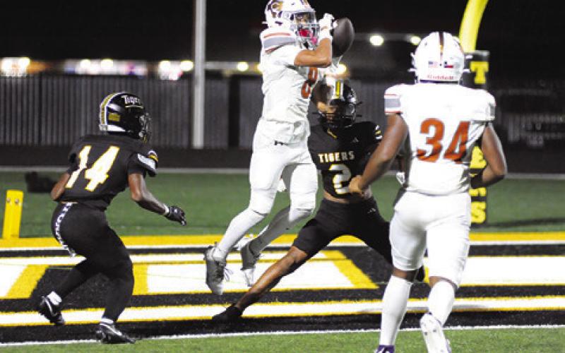 DYLAN CARTER OF Caldwell reaches for this pass against Sealy. Also pictured is teammate Michael Butler. Tribune photo by Denise Squier