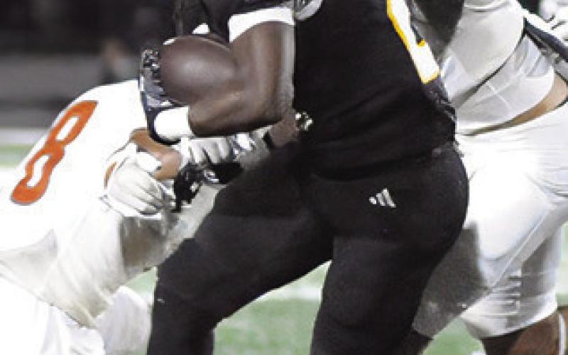 DYLAN CARTER AND Zane Brown of Caldwell make at tackle against Sealy. Tribune photo by Denise Squier