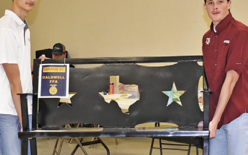 COOPER ODENBACH AND Nathan Scott display this auction item on Saturday at the Burleson County Go Texan Annual Auction.
