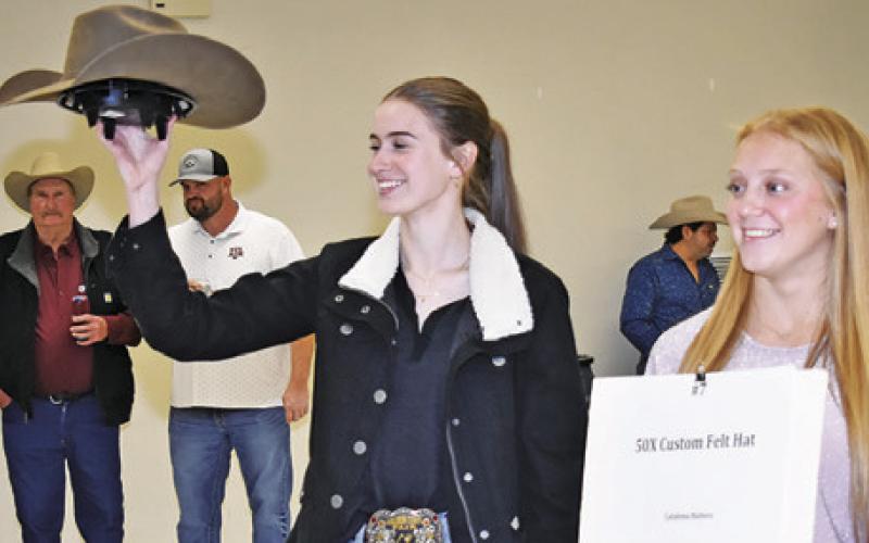 MARY HANCOCK and Caitlyn Faust display these items at the Burleson County Go Texan Annual Auction last Saturday.