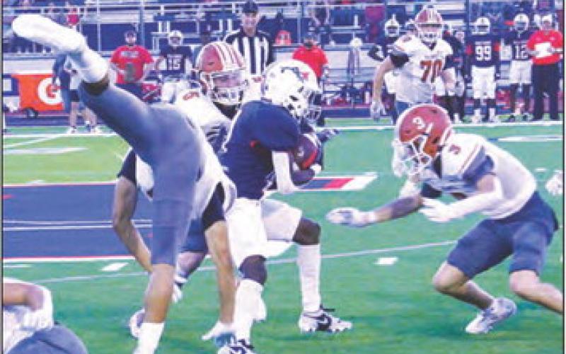 E.J. ROGERS, CORBIN Stewart and Caden Schluens defend against this Madisonville running back. -- Tribune photo by Roy Sanders