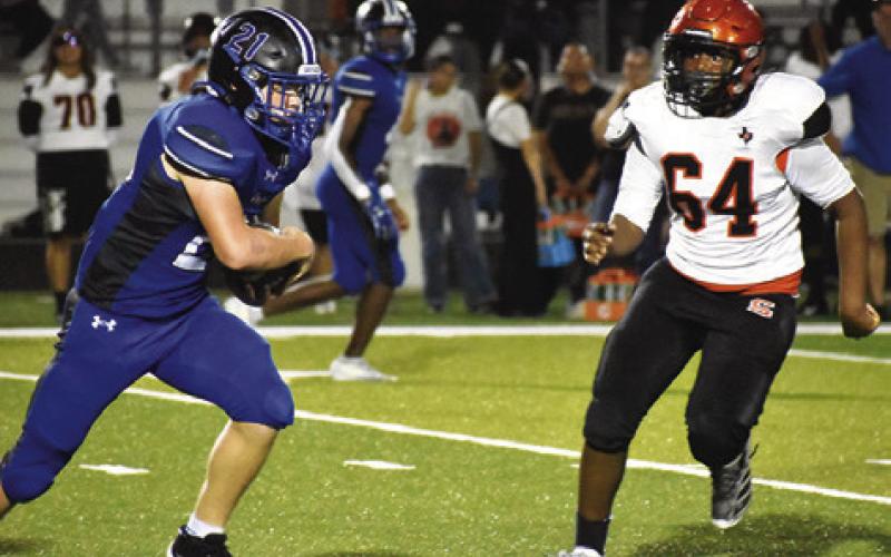 SNOOK’S MICHAEL EATON carries the ball, and Somerville’s Tory Brown approaches for the tackle in last Friday’s game in Snook.