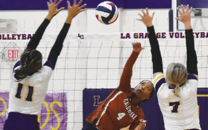 CALDWELL’S TYNIAH JOHNSON gets one of her 22 kills against La Grange last Friday night, hitting the ball betweek La Grange blockers, Brion Williams and Kenna Lamza. Tribune photo by Roy Sanders