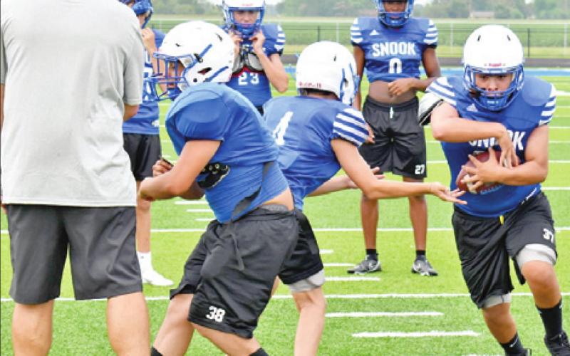 FULLBACK JACOB CASTANEDA takes the handoff from quarterback Caden Schluens. Also pictured is left guard Richard Santillan. The Bluejays are getting ready for the 2021 football season.
