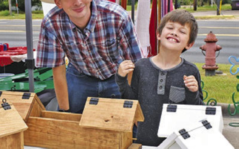 JUDAH CAVENS, right, displays his work at the Artisans Woodshop display on Sunday, Sept. 1, at the Somerville Farmers Market. Also pictured is Matthew Cravens.