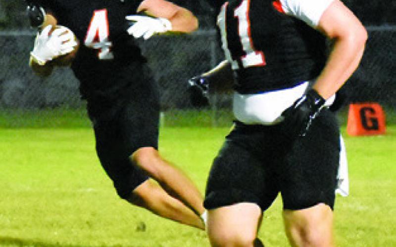 GABRIEL McDONALD carries the ball against Weimar. Also pictured is Luke Moses. Tribune photo by Roy Sanders