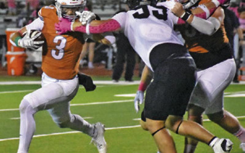 COY BECKA OF Caldwell carries the ball against Giddings. Also pictured is teammate Chase Clark. Caldwell won 44-14. Tribune photo by Roy Sanders