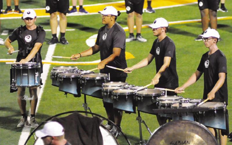 MEMBERS OF THE GENESIS drum line perform a cadence during Saturday night at Hornet Field. -- Tribune photo by Denise Squier
