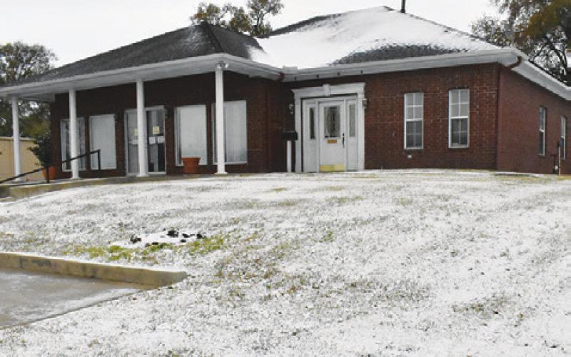 THE BURLESON COUNTY TRIBUNE looks wintry with the blanket of snow in front of the building. The county received a little under an inch of snow from Monday night into Tuesday morning. Tribune photo by Roy Sanders