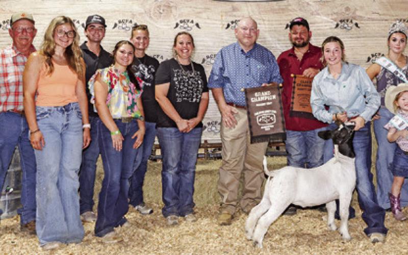 RAELEIGH USSERY EXHIBITED the Grand Champion Goat at the 2025 Burleson County Fair. Also pictured are Lee Whitlock, Lauren Renfro, Blake Jackson, Jessica Atkinson, Emory Vollentine, Randi Ussery, Judge Marty Gibbs, Kody Fisher, Burleson County Fair Queen Kodi Hitchcock and Little Miss Taytum Hohlt.