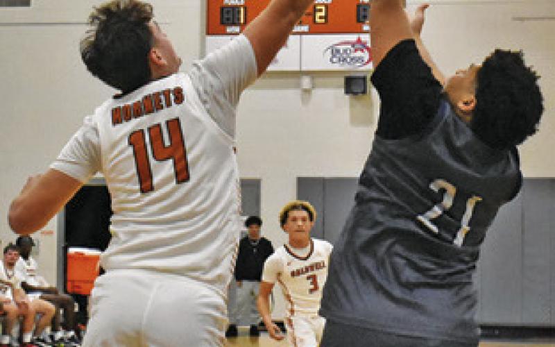JOHN FRYREAR OF Caldwell reaches high for this rebound against Bryan JV. Tribune photo by Roy Sanders