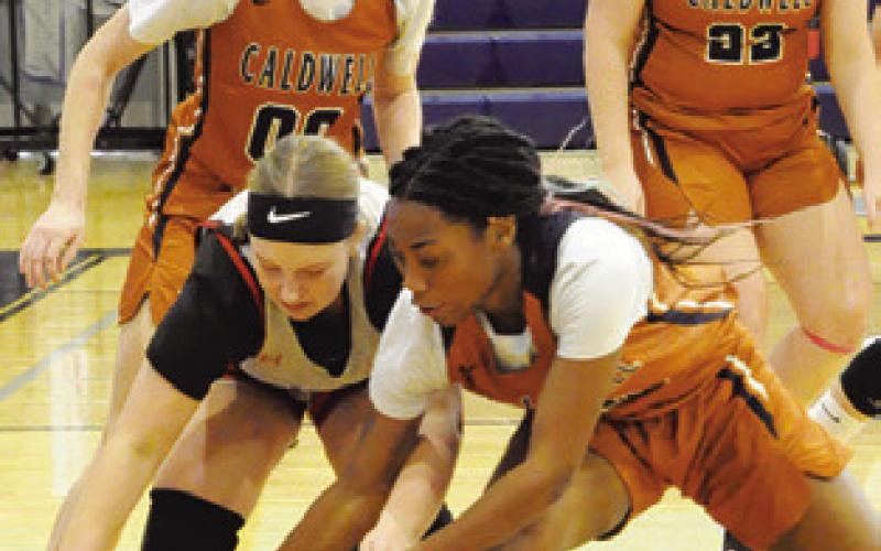AYANNA DEWBERRY fights for possession of the ball with a Burton JV player during the Lady Hornet Classic Basketball Tournament. Tribune photo by Denise Squier
