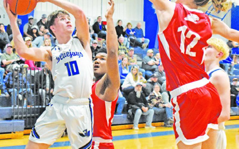 LANCE LARA OF Snook jumps high for this shot despite some defensive pressure from Burton. -- Tribune photo by Roy Sanders
