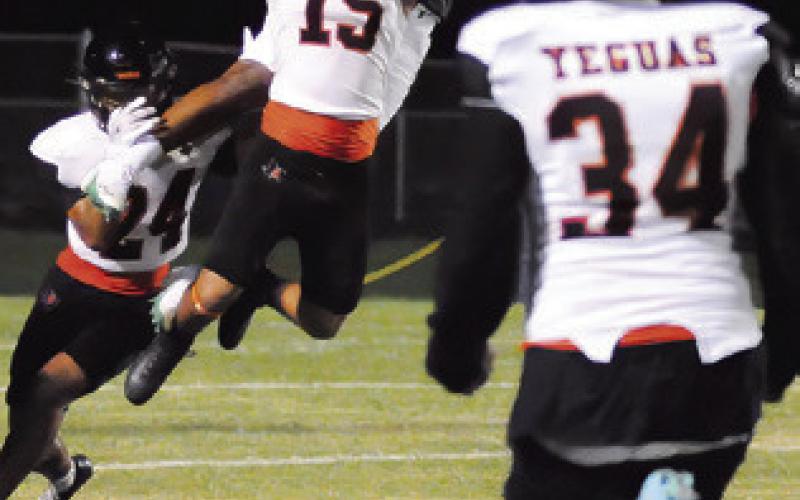 ULISSES PEREZ-MENDEZ leaps high to break up this pass as teammates Kaleb Leang and Jayden Espinosa approach. Somerville won 34-18. Tribune photo by Denise Squier